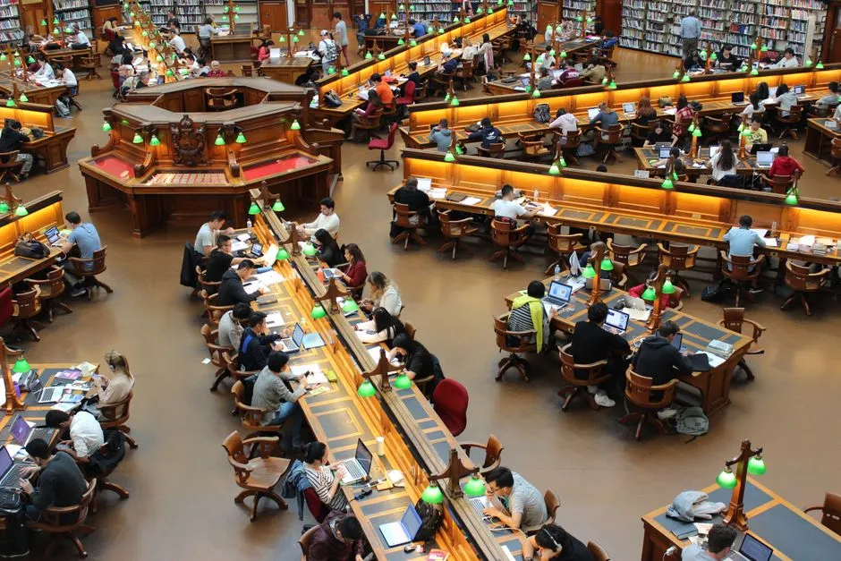 Students studying together at tables in a college library
