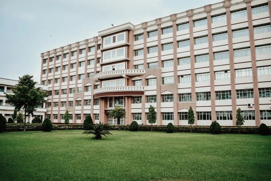Large modern university building with a landscaped lawn